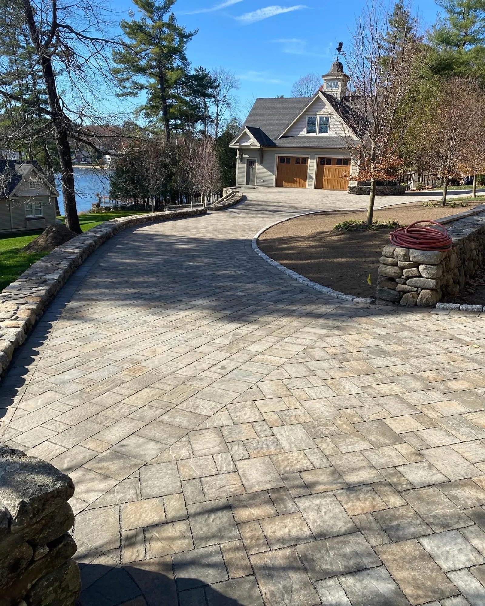 Lakeside paver driveway and fieldstone wall built by Tamarack Landscaping